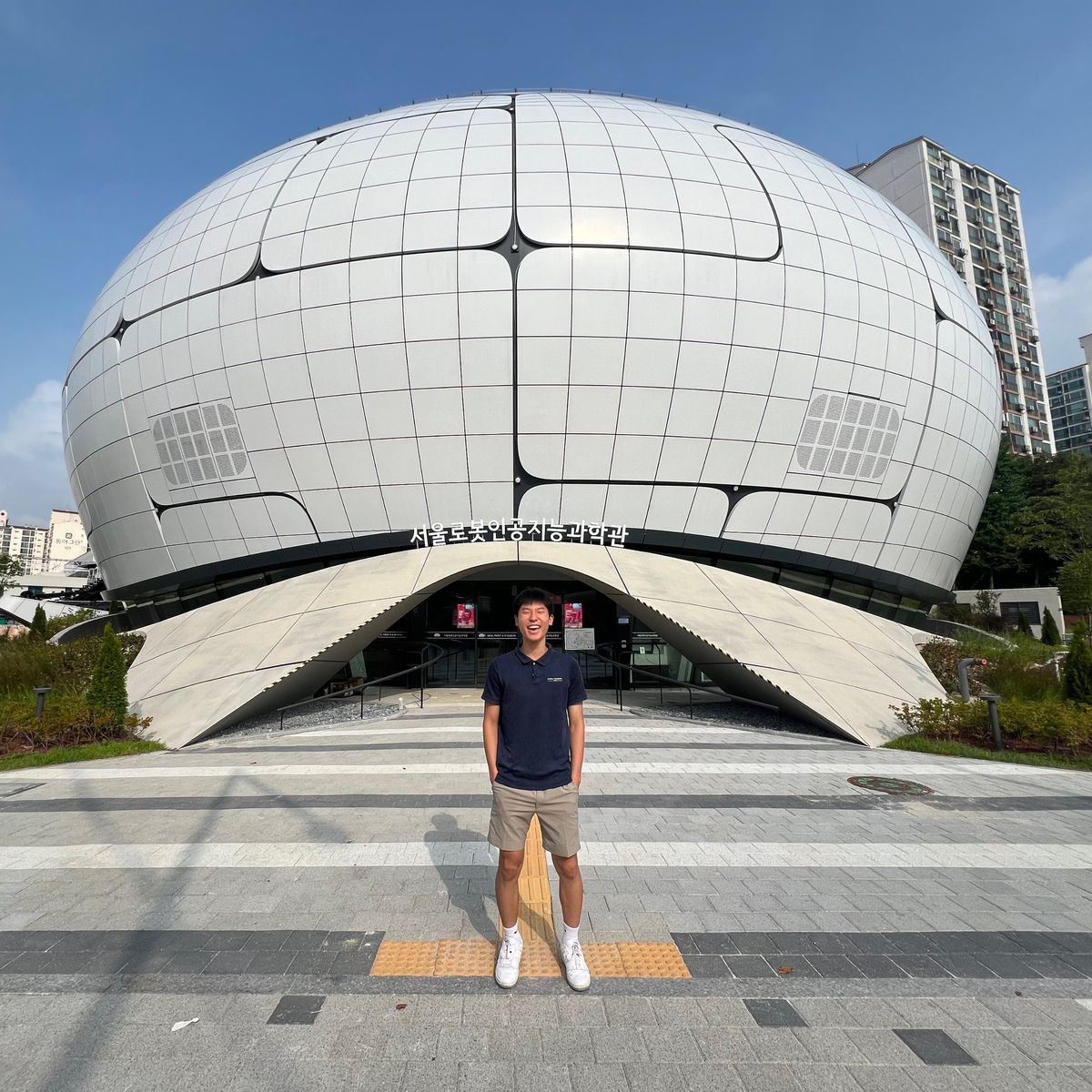 Ethan standing in front of the dome-shaped Seoul Robot & AI Museum building