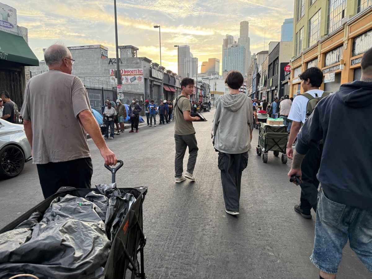 Ethan walking down a Skid Row street with the delivery team at sunset