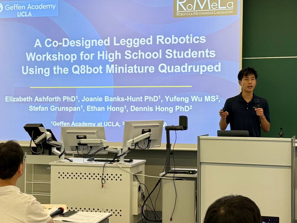 Ethan presenting the title slide of the Q8bot legged robotics workshop paper at UR2026